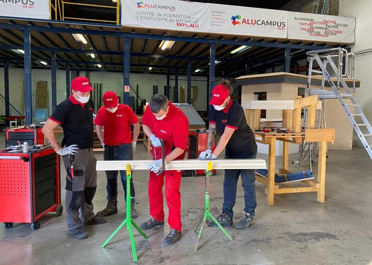 Apprentis en formation travaillant sur une pièce en aluminium.